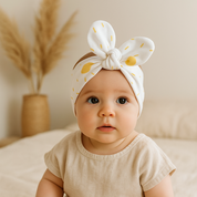 Laço de cabelo para bebê em algodão stretch com estampa exclusiva de solzinhos dourados sobre fundo branco, acabamento premium e modelagem confortável para crianças.