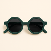 Óculos de sol infantil redondo com armação verde escuro fosca e lentes escuras, modelo unissex da marca Means Love Baby