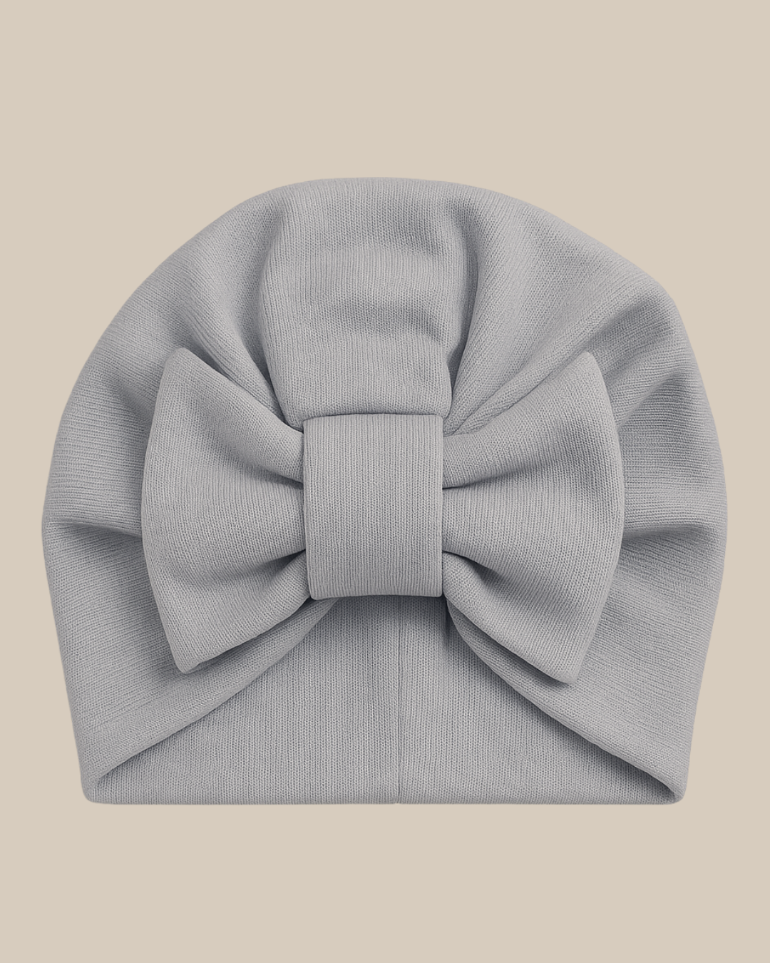 Bebê de 1 ano ao ar livre usando turbante azul serenity com laço, vestindo roupa neutra que combina com o acessório.